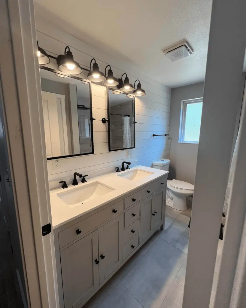 A modern white bathroom with two sinks, two mirrors, and 6 lamps to light