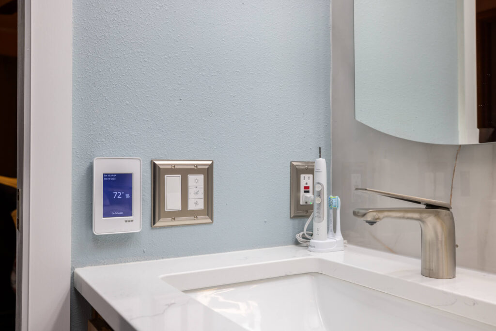 Bathroom sink with smart thermostat and toothbrush.